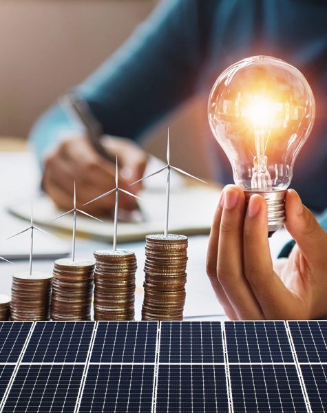 businesswoman holding light bulb with turbine on coins and solar panel. concept saving energy and finance accounting