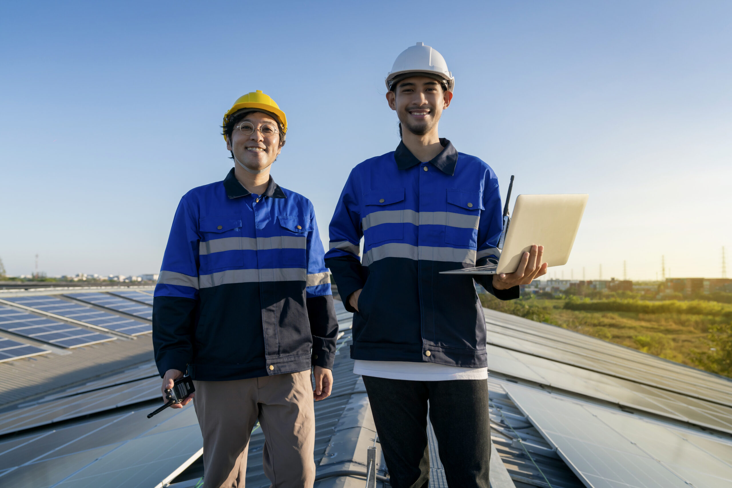 portrait smiling professional engineer with laptop tablet maintenance checking installing solar roof panel factory rooftop sunlight engineers team survey check solar panel roof scaled